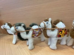 トルクメニスタン館のお土産物コーナーに並ぶラクダのぬいぐるみ
